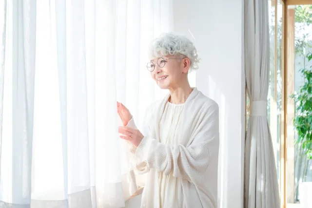 窓の外を眺める高齢女性