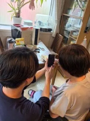 スマートフォンを見る男性と高齢女性