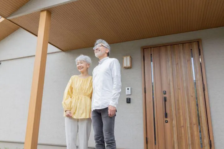 遠くを微笑みながら見つめるシニアの夫婦